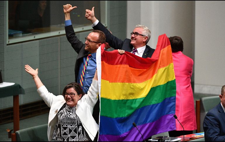Los diputados Cathy McGowan (i), Adam Brandt (c) y Andrew Wilkie (d) celebran la aprobación del matrimonio entre personas del mismo sexo en el Parlamento en Canberra. EFE/M. Tsikas