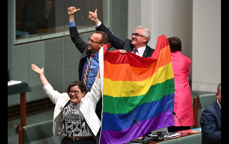 Los diputados Cathy McGowan (i), Adam Brandt (c) y Andrew Wilkie (d) celebran la aprobación del matrimonio entre personas del mismo sexo en el Parlamento de Australia, en Canberra. AP/M. Tsikas