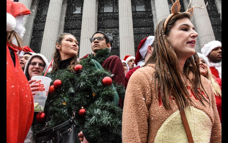 Entre los disfraces destacan una mujer vestida de reno y otra más de árbol de navidad. AFP / S. Keith