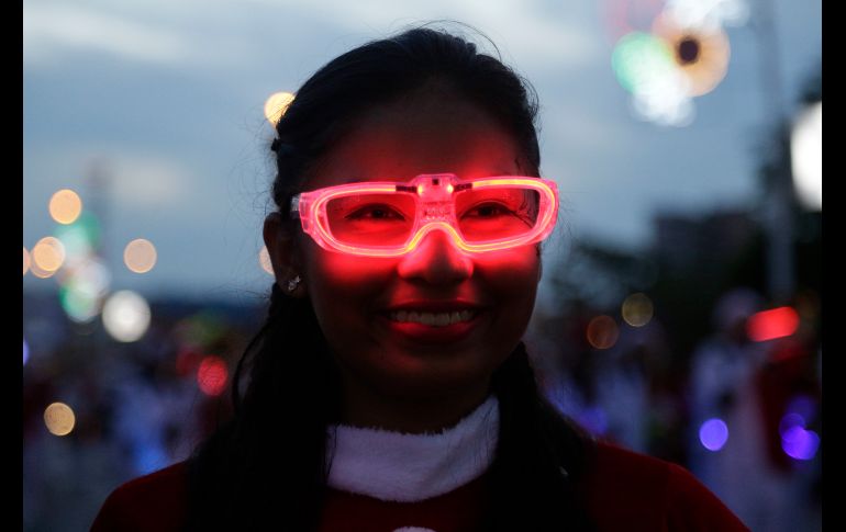 Estefani García porta lentes con luces mientras marcha en el desfile navideño en la Ciudad de Panamá. AP/A. Franco