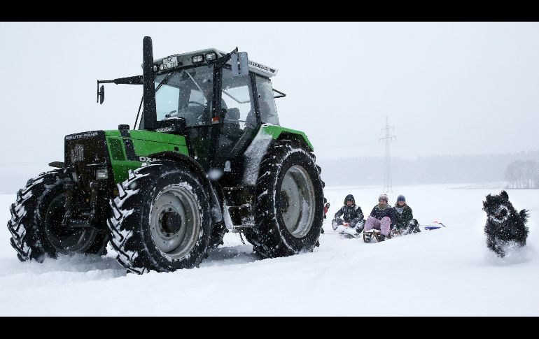 Alemania también se despertó este domingo bajo una capa de nieve y temperaturas que rondaban los cero grados. Un tractor jala trineos en Unlingen-Moehringen, al sur de Alemania.