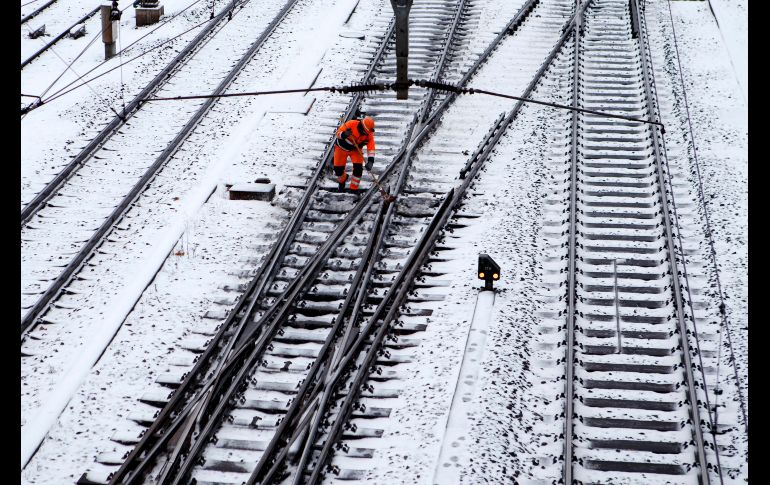 Un trabajador limpia las vías de trenes en Ginebra, Suiza.