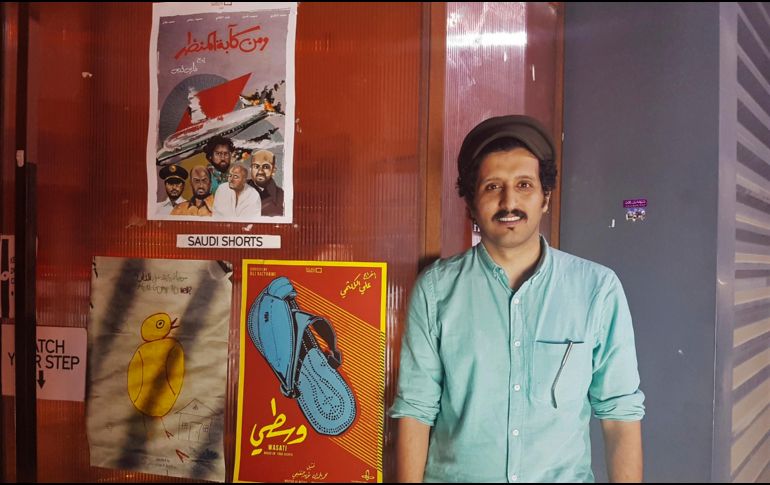 El cineasta saudí Ali Kalthami posa junto al póster de su película 