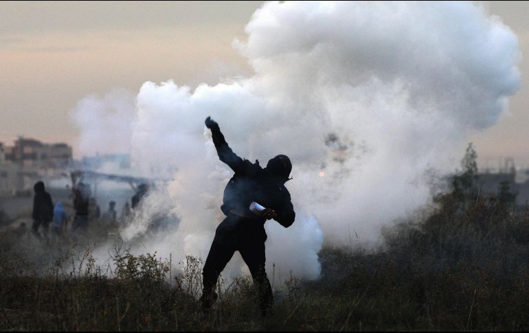Un manifestante palestino devuelve una granada de gas israelí durante enfrentamientos cerca a la frontera con Israel. EFE/M. Saber