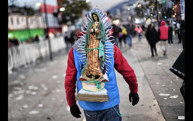 Un peregrino con una figura de la virgen de Guadalupe camina en procesión a la Basílica de Guadalupe en Ciudad de México. AFP/P. Pardo