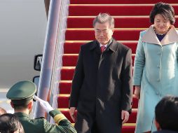 El presidente surcoreano, Moon Jae-in (c), y la primera dama Kim Jung-sook descienden del avión a su llegada a Pekín. EFE/YONHAP