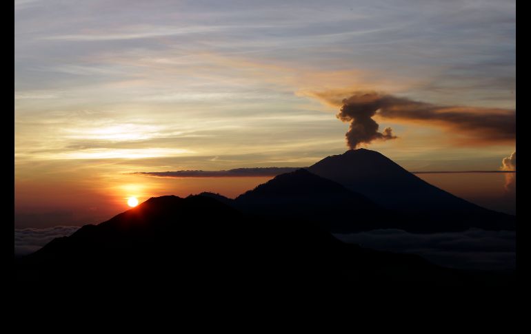 El volcán Agung arroja humo al amanecer en la isla de Bali, Indonesia. La alerta por la actividad volcánica permanece en su máximo nivel. AP/F. Lisnawati