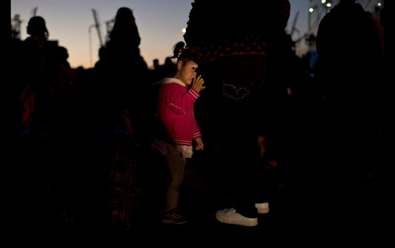 Una niña afgana se recarga en su madre tras llegar al puerto griego del Pireo con un grupo de migrantes y refugiados. AP/P. Giannakouris