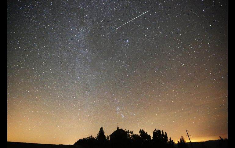 Una lluvia de meteoros gemínidas se ve sobre una iglesia ortodoxa en la villa de Zagorie, Bielorrusia. EFE/T. Zenkovich