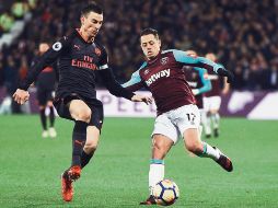 Javier “Chicharito” Hernández (derecha), quien disputa el balón con Laurent Koscielny, del Arsenal, estuvo a punto de poner el gol que hubiera significado el triunfo para el West Ham en la Premier League. EFE