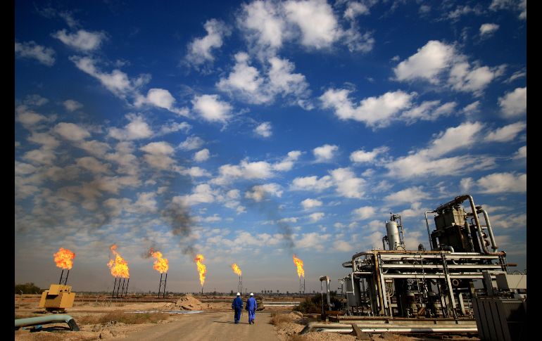 Trabajadores caminan en la planta de gas natural  Bin Omar en la ciudad iraquí de Basra. AFP/H. Mohammed Ali