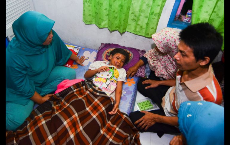 Familiares confortan a una niña que resultó herida en Tasikmalaya.