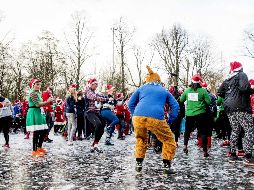 Gente vestida con sombreros de Santa Claus asiste a un 