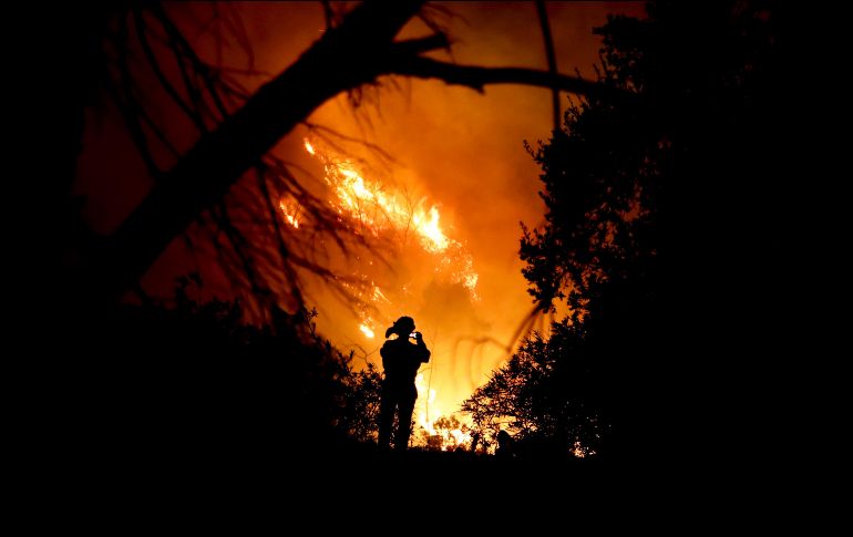 Un bombero toma una fotografía durante un incendio forestal en Montecito, California. AP/C. Carlson