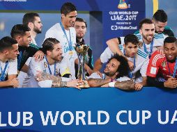 Embelesados. Sergio Ramos, Raphael Varane y Marcelo observan el trofeo que los acredita monarcas del Mundial de Clubes. AFP