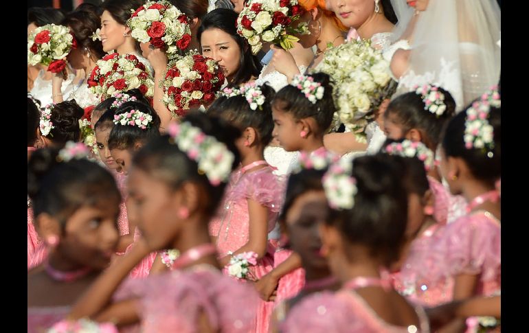 Parejas y damas asisten a una ceromia para casar a 50 parejas chinas en Colombo, Sri Lanka. AFP/I. S. Kodikara