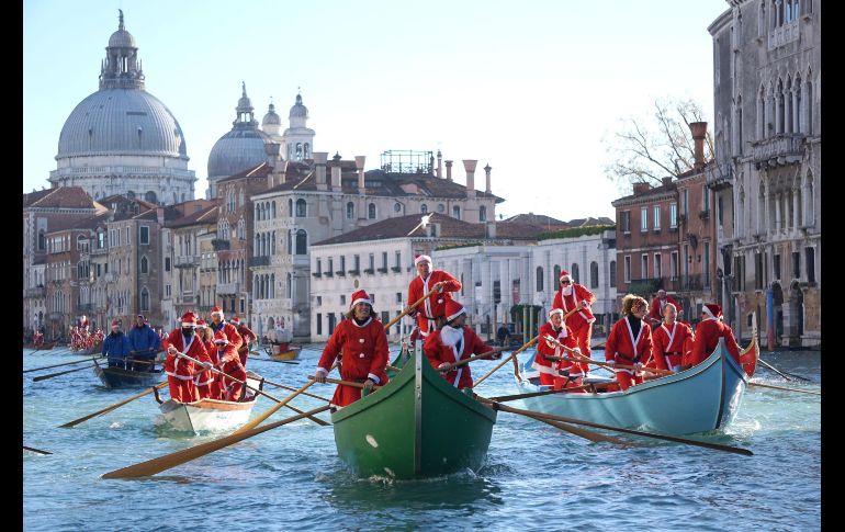 Botes navegan en un canal de Venecia, Italia, durante la tradicional procesión de Santa Claus, en la que participaron unos 200 remeros. AP/ANSA/A. Merola