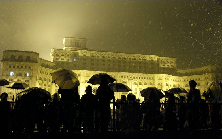 Sin importar la lluvia ni el frío, los rumanos permanecieron frente al parlamento gritando sus consignas. EFE/ R. GHEMENT