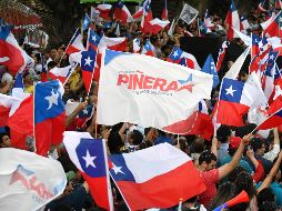 Centenares de chilenos se apretujan frente al edificio céntrico en el que se ubica el comando de Piñera. AFP / M. Bernetti