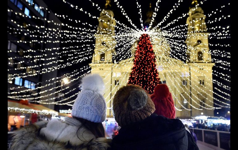 Un grupo de visitantes observan árbol de Navidad junto a la Basílica de san Esteban, en el centro de Budapest, Hungría. EFE/Z. Mathe