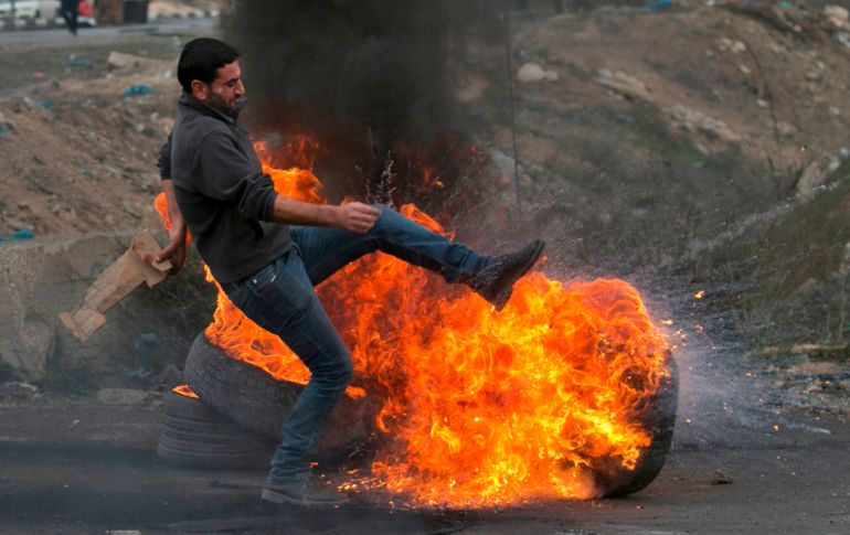 Un palestino patea una llanta en llamas durante enfrentamientos con fuerzas de seguridad israelíes cerca del punto de revisión de Huwara, en la zona de Cisjordania ocupada por Israel. AFP/J. Ashtiyeh