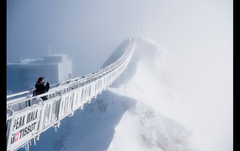 Una turista toma una foto de un puente de suspensión en Glacier 3000, el glaciar en el paso de montaña Col du Pillo, en los Alpes Suizos. AP/Keystone/C. Bott
