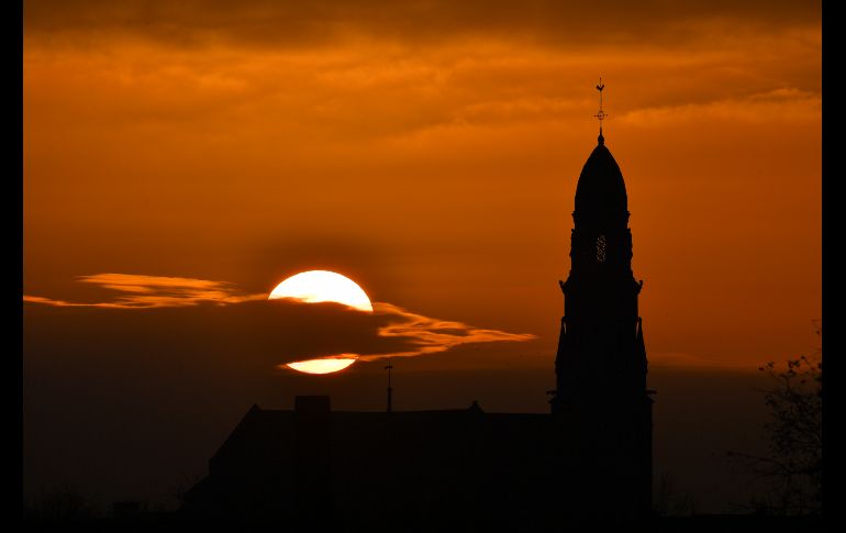 El Sol se pone tras un templo católico en Saint Fiacre sur Maine, en el oeste de Francia. AFP/L. Venance
