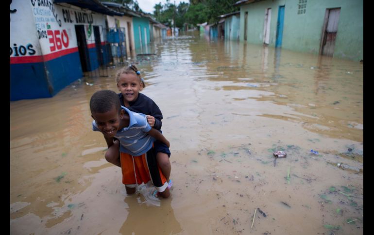 HIGÜEY, REPÚBLICA DOMINICANA (21/SEP/2017).- Nińos del barrio La Florida caminan por una calle inundada. María ha provocado el desplazamiento de más de 14 mil personas en el país. EFE/O. Barría