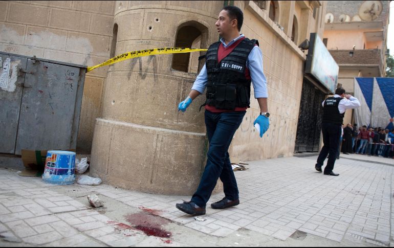 Un miembro de las Fuerzas de Seguridad pasa junto una mancha de sangre junto a la iglesia Mar Mina tras el ataque. EFE/M. Hosan