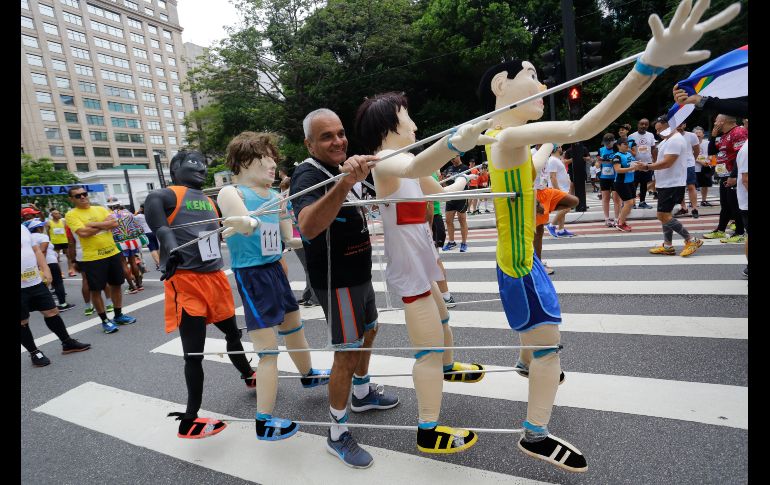 Un corredor anda con muñecos previo al arranque de la carrera de Sao Silvestre en Sao Paulo, Brasil. AP/N. Antoine