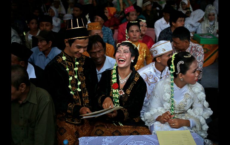 Unos novios se ríen durante una boda masiva en Yakarta, Indonesia, realizada por el gobierno local para apoyar a quienes no pueden costear la ceremonia. AP/D. Alangkara