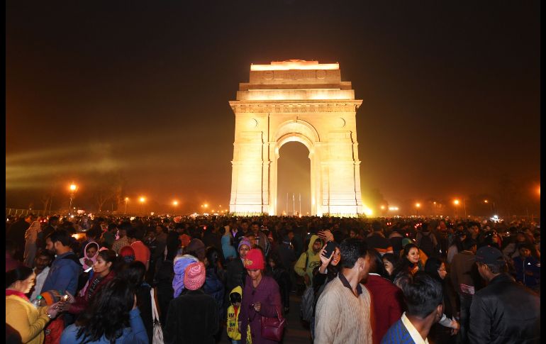 Personas se reúnen en la puerta India de Nueva Delhi. Miles de millones de personas alrededor del mundo asisten a las ceremonias de bienvenida al año 2018.