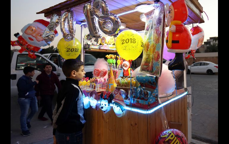 Un niño observa decoraciones para el Año Nuevo en la ciudad iraquí de Najaf. AFP