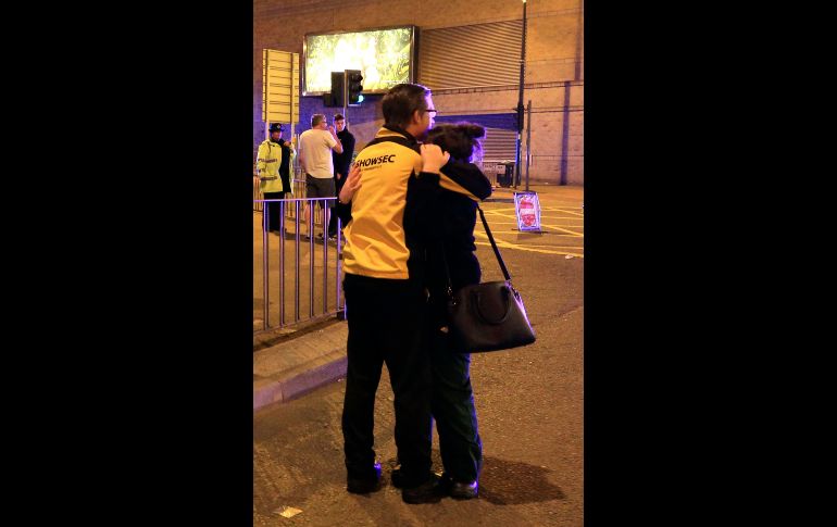 MANCHESTER, INGLATERRA (22/MAY/2017).- Personas reaccionan. Poco antes de las 23:00 locales, empezaron a circular en las redes sociales noticias de dos explosiones en el pabellón británico, al término del concierto. AP/P. Byrne
