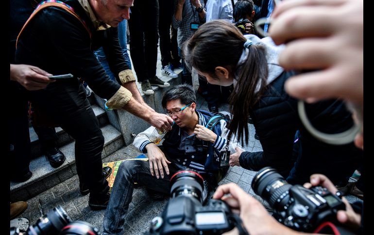 Un manifestante reacciona luego de que la policía lo quitó de un asta de bandera en la Plaza Cívica, a donde se había subido durante protestas a favor de la democracia en Hong Kong, China. AFP/A. Wallace