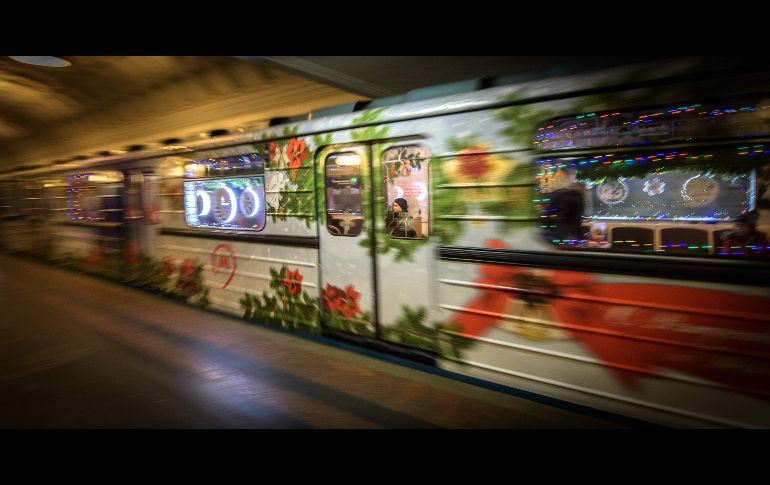 Pasajeros se trasladan en un vagón del metro decorado con motivos de Año Nuevo en Moscú, Rusia. AFP/Y. Kadobnov