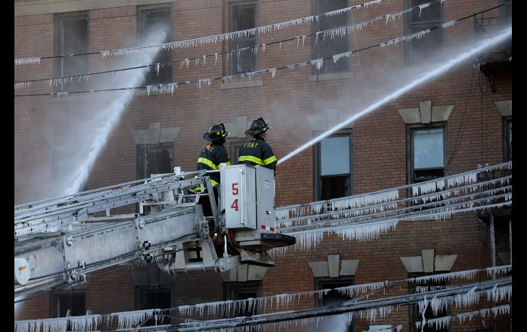 Témpanos cuelgan de cables mientras bomberos realizan labores de extinción de fuego en un edificio de apartamentos en El Bronx de Nueva York, Estados Unidos. El incendio ha dejado al menos 16 heridos. AP/S. Wenig