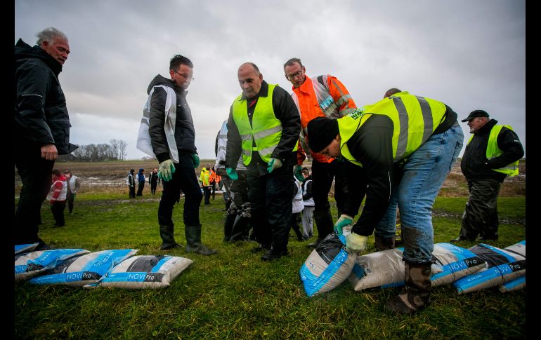 Voluntarios colocan sacos de arena cerca de diques en Kampen, Holanda. En este país se cancelaron 252 de los mil 200 vuelos con salida del aeropuerto Schiphol de Amsterdam, uno de los más importantes de Europa.