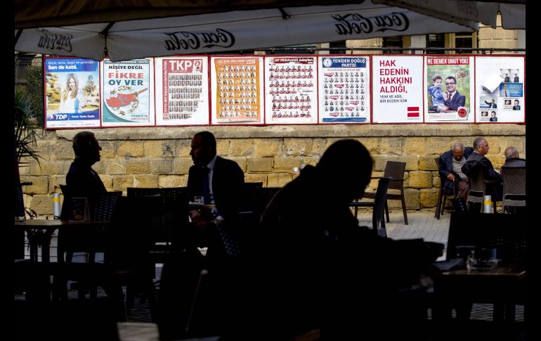 Personas se sientan en un café con pósters de la campaña parlamentaria en la parte norte de Nicosia, en la autoproclamada República Turca del Norte de Chipre, solo reconocida por Turquía. AFP/B. Bebek