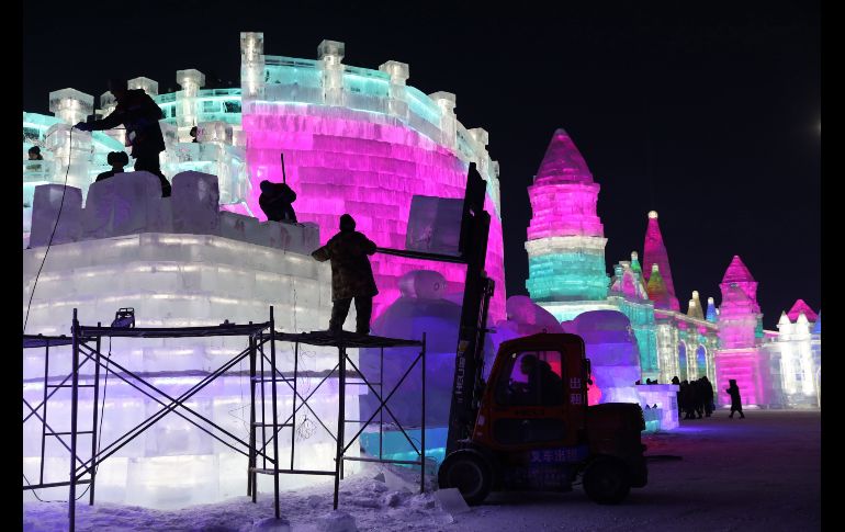 Trabajadores construyen una escultura de hielo.