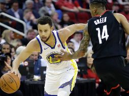 La estrella Stephen Curry conduce el balón ante la marca de Gerald Green (#14), de los Rockets, durante el juego de ayer. AP/D. Phillip
