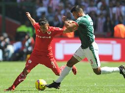 En la foto, Alexis Vega del Toluca pelea por el balón con Hedgardo Marín, de Chivas. AFP / R. Vázquez