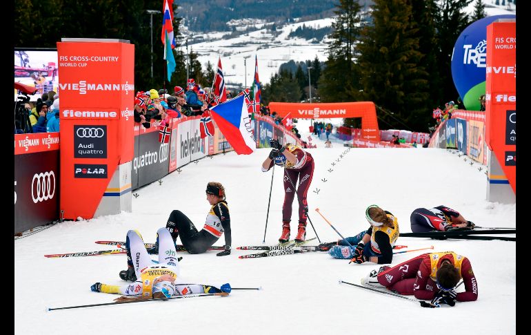 Esquiadores reaccionan tras cruzar la meta en la competencia femenil de persecución estilo libre, en el tour de la Copa del Mundo de Esquí disputado en Cavalese, Italia. AFP/A. Solaro