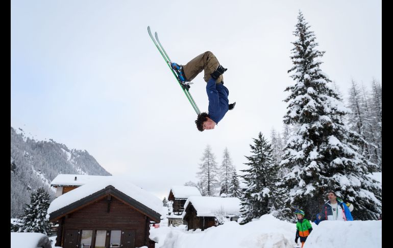 Un adolescente hace una voltereta con esquís en Zinal, en los Alpes Suizos, luego de que se reabrió el acceso al poblado, pues había quedado cortado por una fuerte nevada. AFP/F. Coffrini