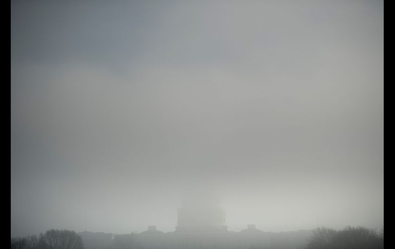 El domo del Capitolio estadounidense en Washington, DC, apenas se distingue entre la niebla. AFP/B. Smialowski