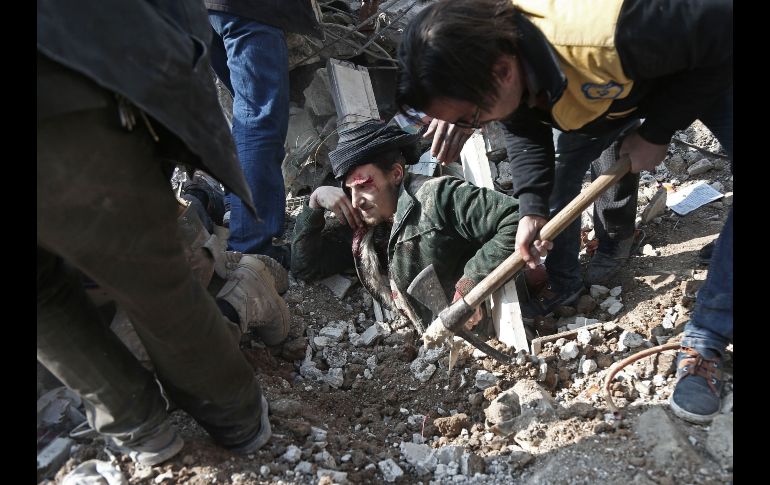 Voluntarios de la defensa civil siria sacan a un hombre de entre los escombros, luego de un ataque aéreo en Saqba, bajo control de los rebeldes opositores al régimen sirio. AFP/A. Eassa