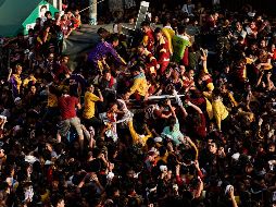 Devotos filipinos intentan alcanzar la imagen del Nazareno Negro durante la multitudinaria procesión que se celebra cada 9 de enero. EFE/R. Cristino