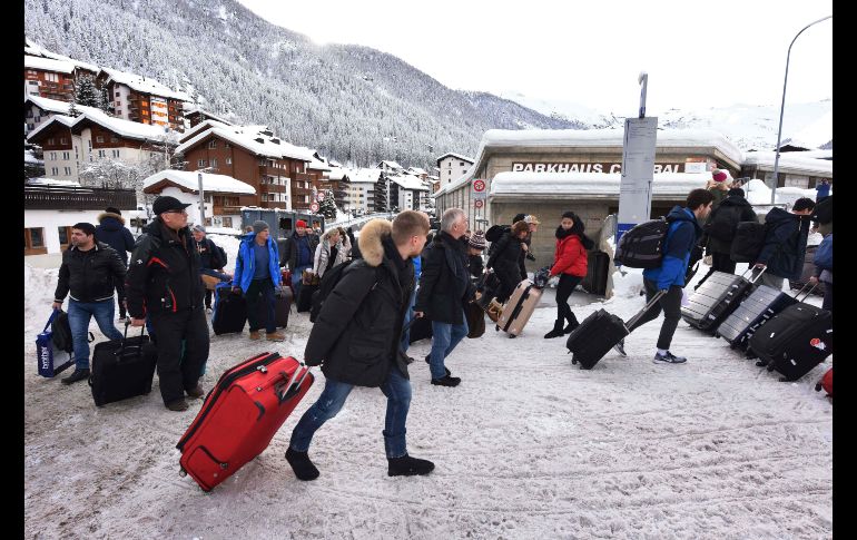 Decenas de turistas se dirigen al helipuerto para ser evacuados de Zermatt, en el sur de Suiza.