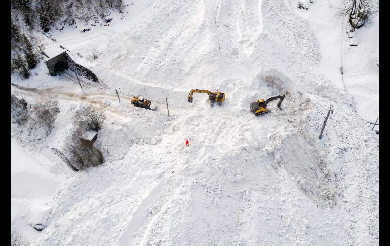 Máquinas quitan nieve en el sitio de una avalancha que cubrió la vía del tren entre Visp y Täsch.