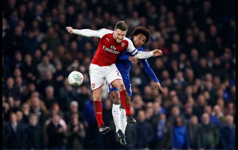 Shkodran Mustafi, del Arsenal, salta por un balón con Willian, del Chelsea, en partido de la Liga Premier inglesa disputado en Londres. AP/K. Wigglesworth